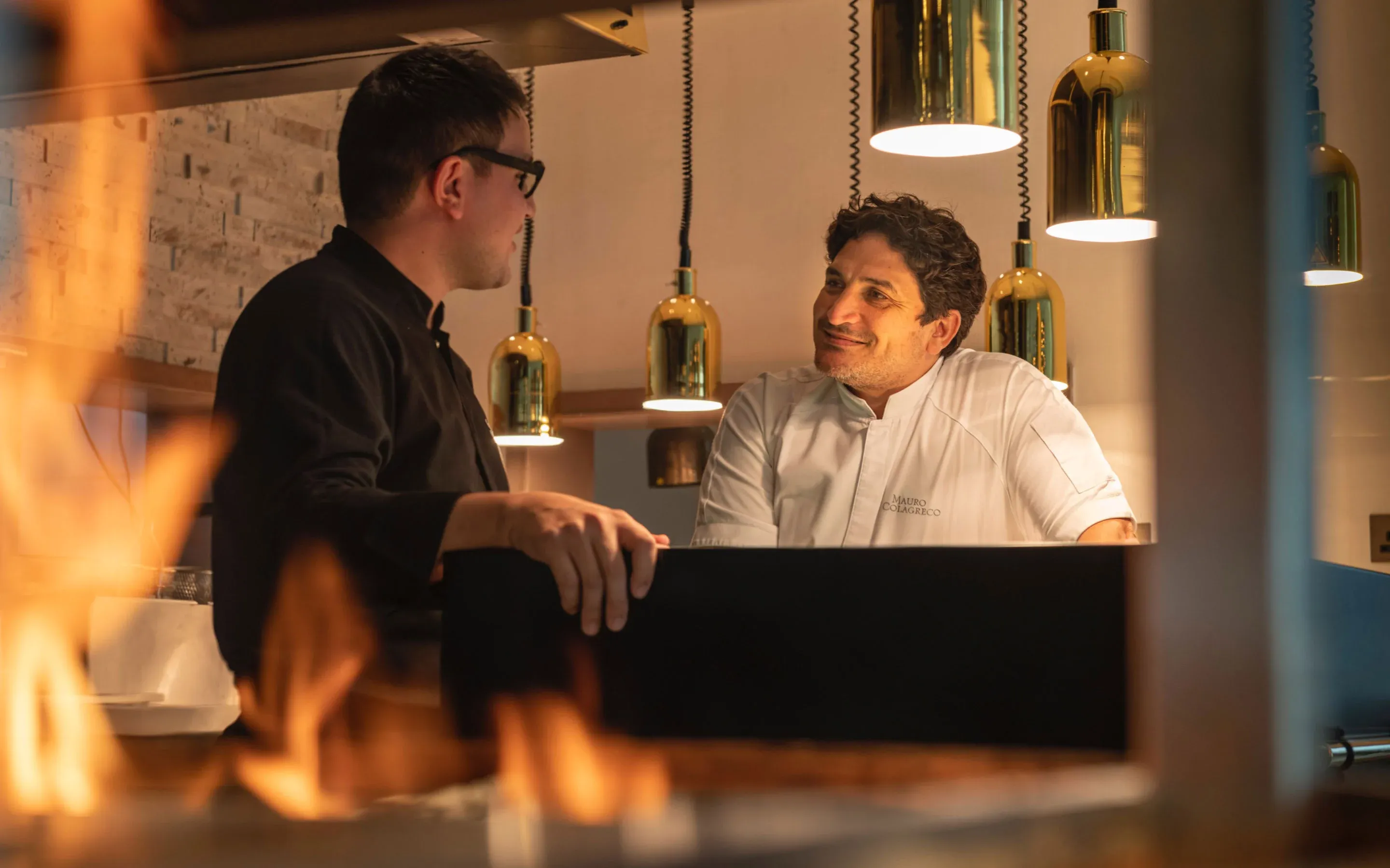 Chef Mauro Colagreco engaging in conversation with a man at One&Only Royal Mirage