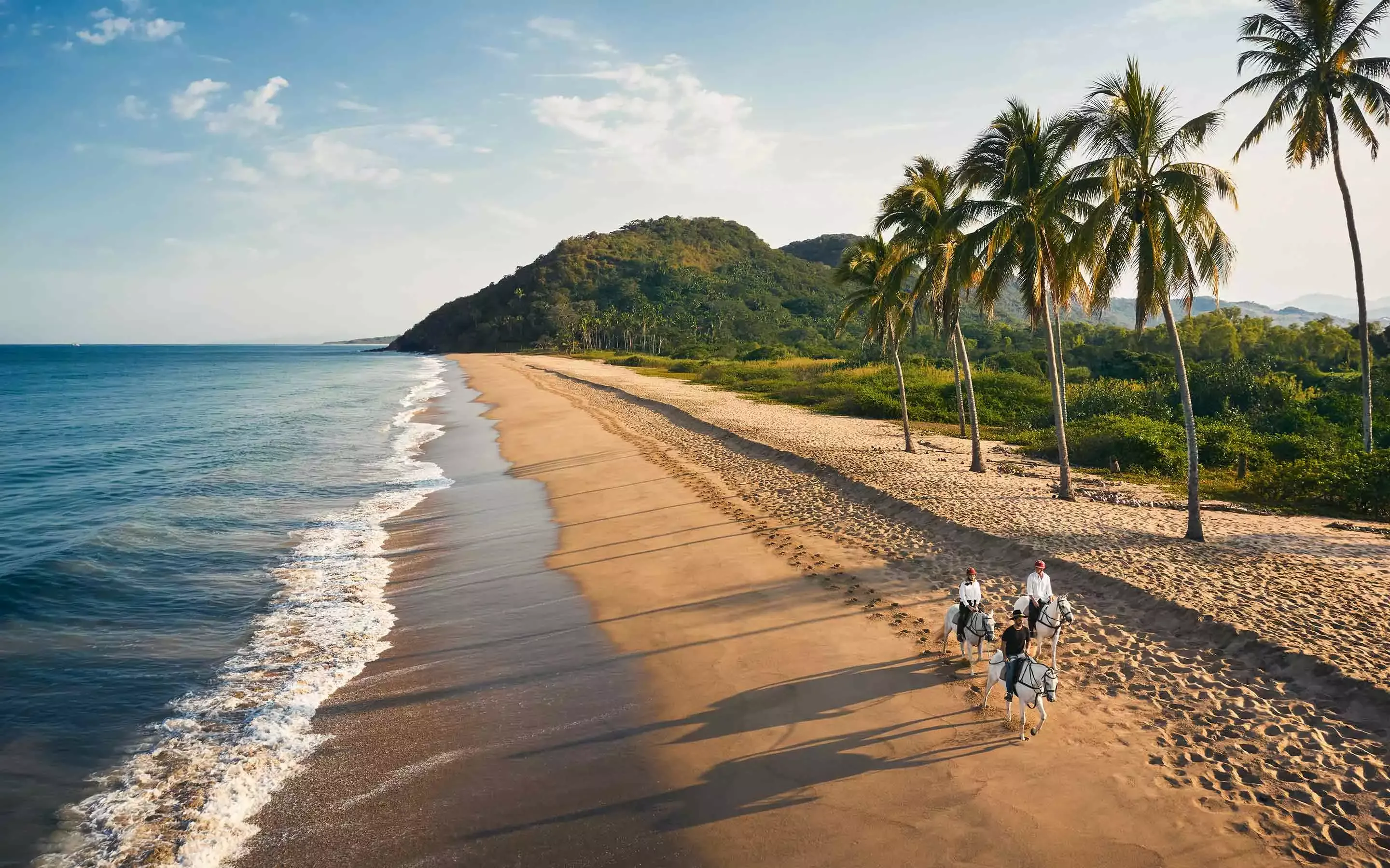 Men riding horses at the beach at One&Only Mandarina