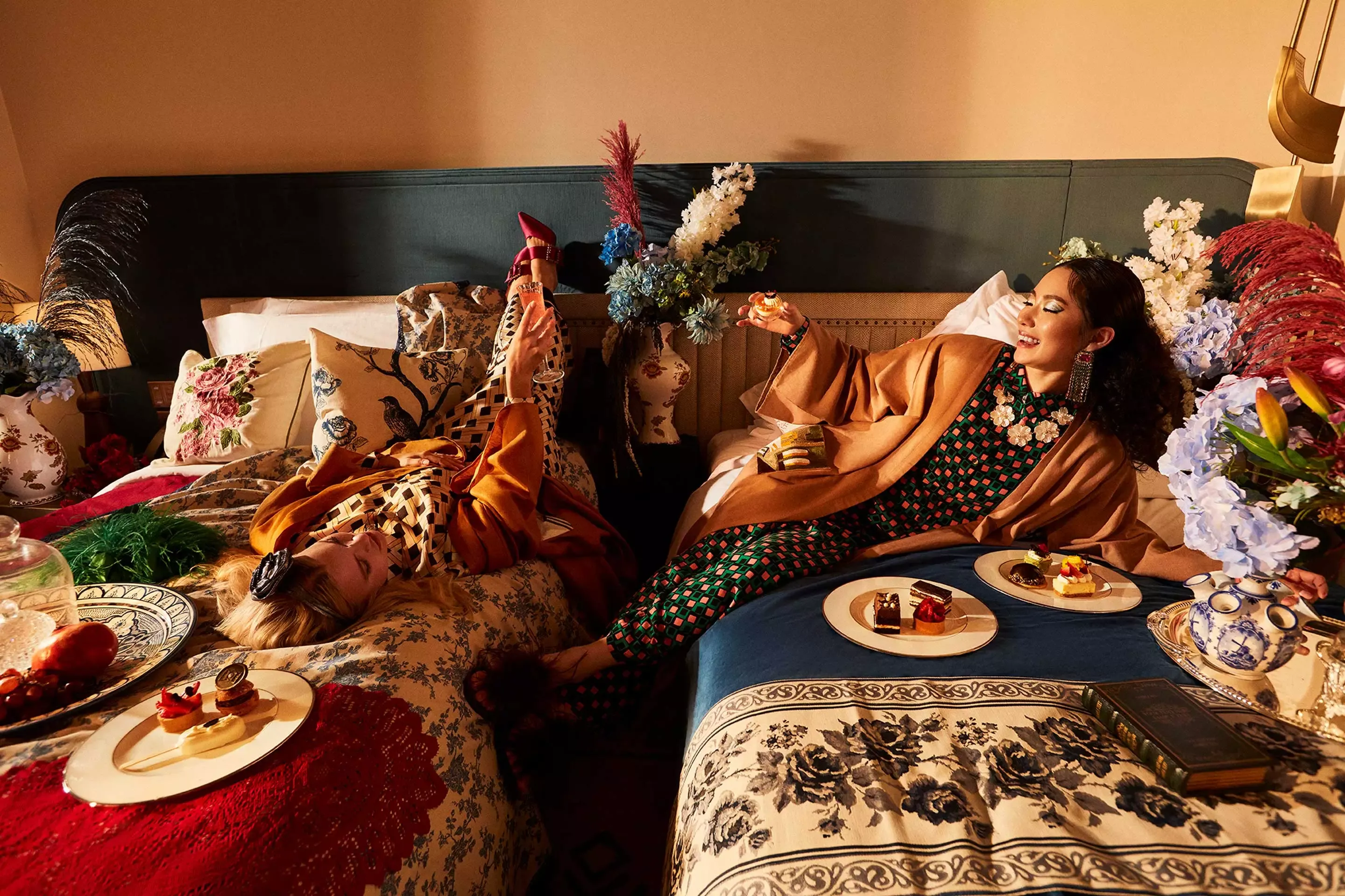 Two women enjoying the meals on their bed at Bab Al Shams