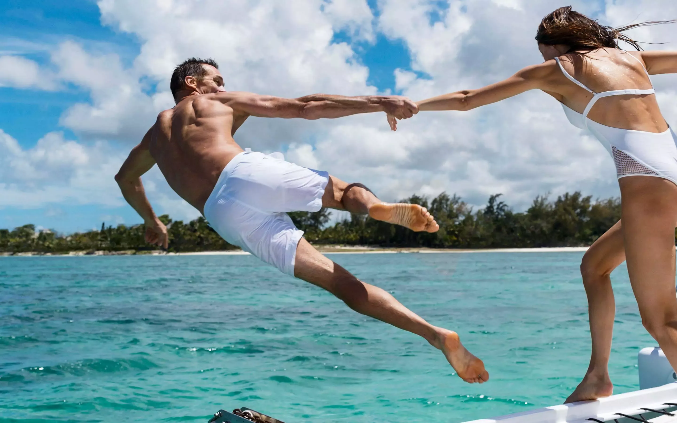 Man And Woman Jumping In the Ocean At One&Only Le Saint Géran
