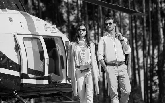 Couple stepping out of a helicopter after landing at One&Only Gorilla's Nest