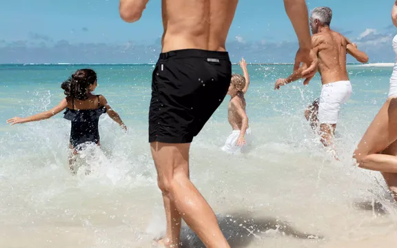 Family running on the beach at One&Only Reethi Rah